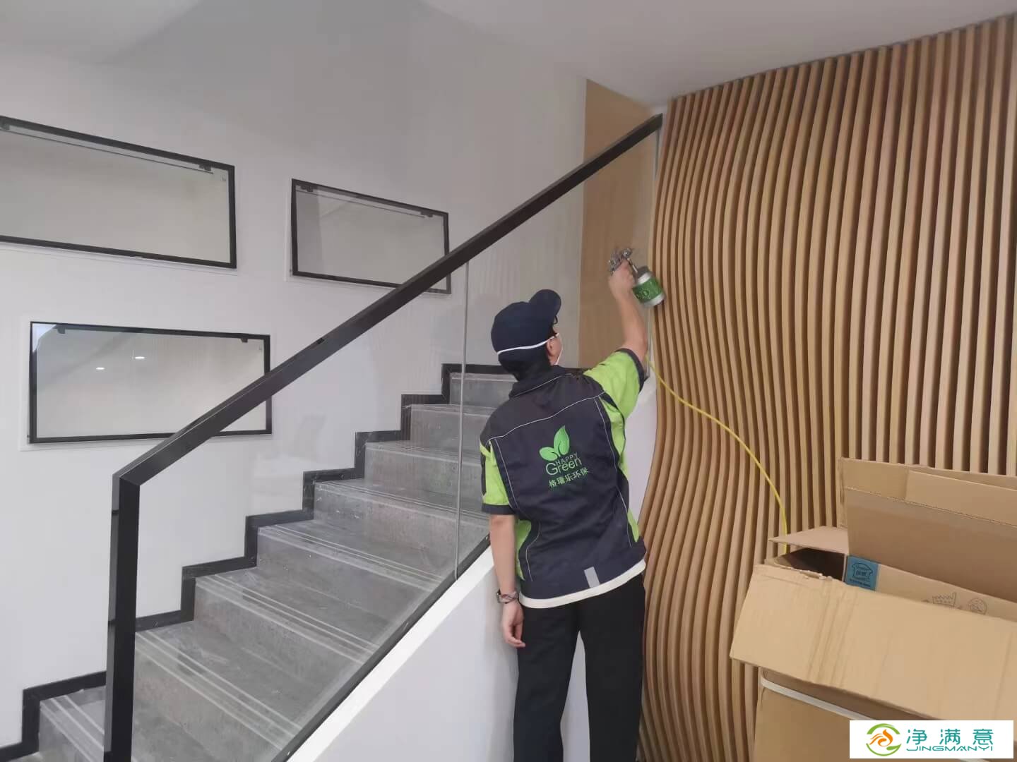 客厅电视背景墙的插座旁的木质装饰条上，工作人员涂抹格瑞乐除甲醛光触媒涂料，利用光线除醛。